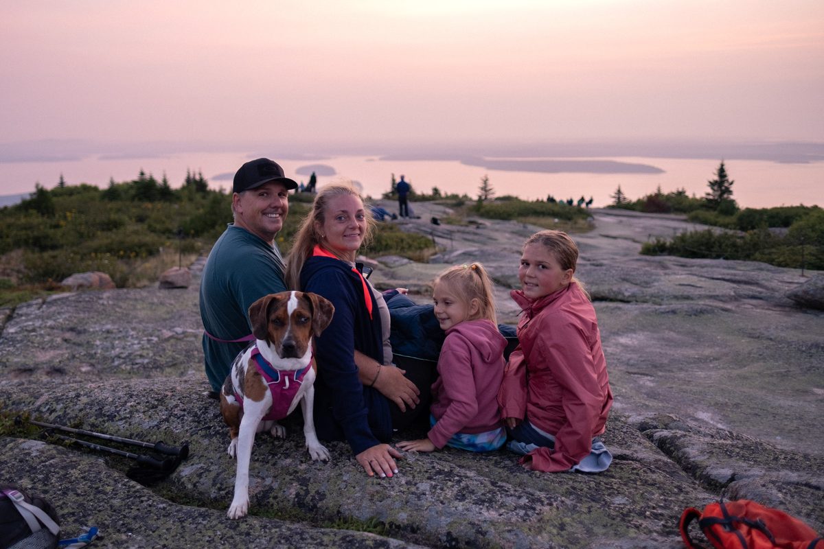 Family on a summit at sunset